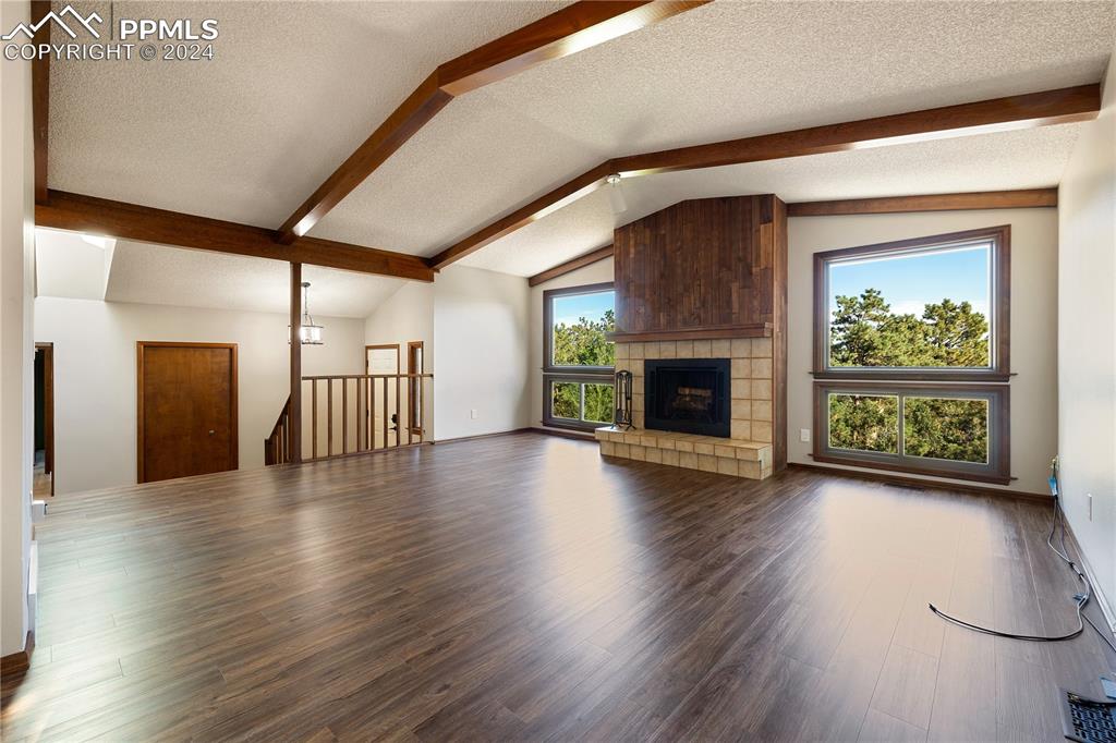1125 Garlock Lane Colorado Springs, CO 80918 - Photo 7 of 49 an empty room with wooden floor fireplace and windows