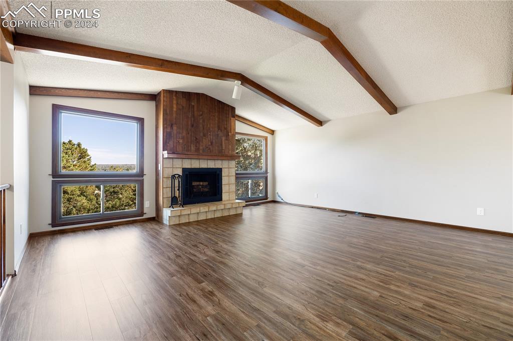 1125 Garlock Lane Colorado Springs, CO 80918 - Photo 8 of 49 a view of a livingroom with wooden floor a fireplace and window