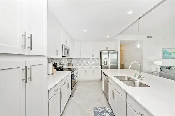 a kitchen with a refrigerator a stove top oven with a dining table and chairs