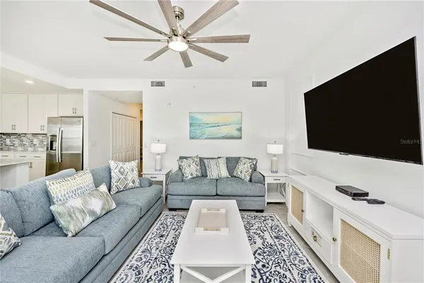 a living room with furniture a flat screen tv and a floor to ceiling window