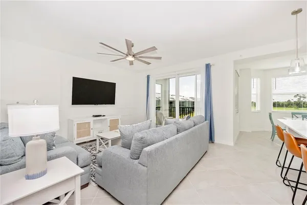 a living room with furniture and a large window with wooden floor