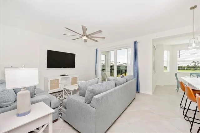 a living room with furniture and a large window with wooden floor