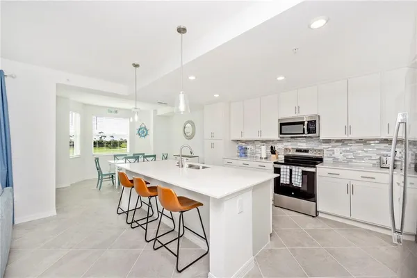 a kitchen with appliances a sink and cabinets