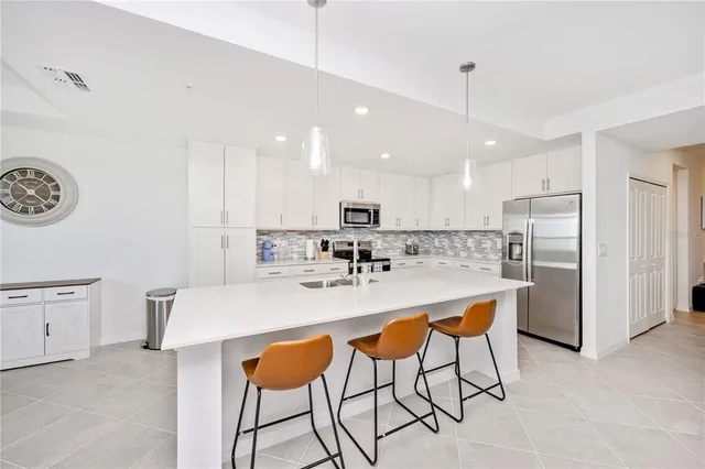 a kitchen with stainless steel appliances granite countertop a sink a stove and a refrigerator