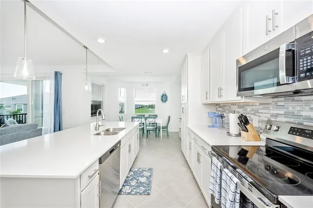 a kitchen with stainless steel appliances a sink and a refrigerator