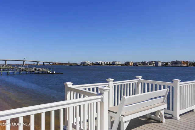 a view of a balcony with wooden chairs and city view