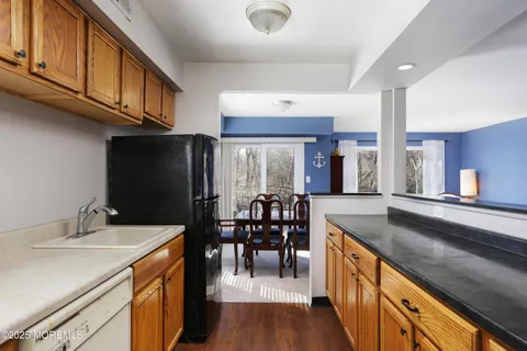 a kitchen with granite countertop a sink appliances and cabinets