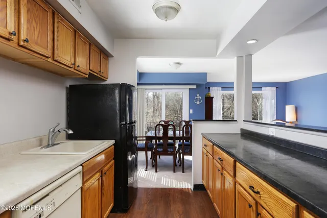a kitchen with granite countertop a sink appliances and cabinets