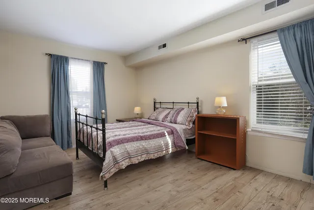 a bedroom with bed couch and window