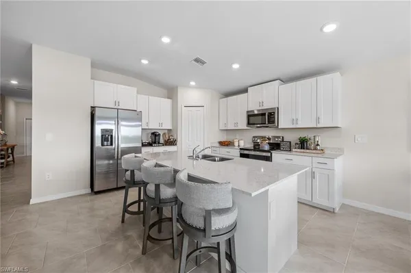a kitchen with stainless steel appliances granite countertop a refrigerator and a stove top oven