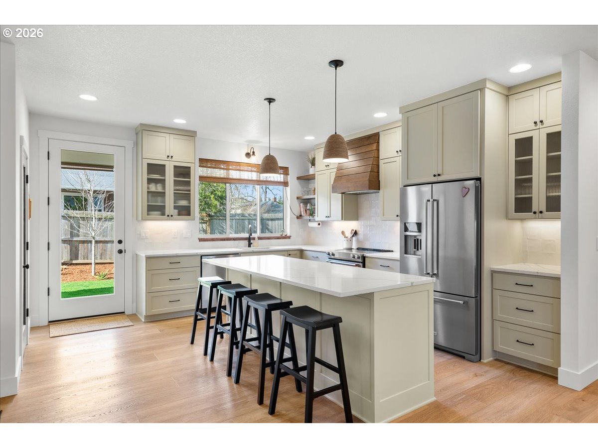 1305 Uff Da Street Silverton, OR 97381 - Photo 15 of 46 a kitchen with stainless steel appliances granite countertop a refrigerator a sink dishwasher a stove and a dining table with wooden floor