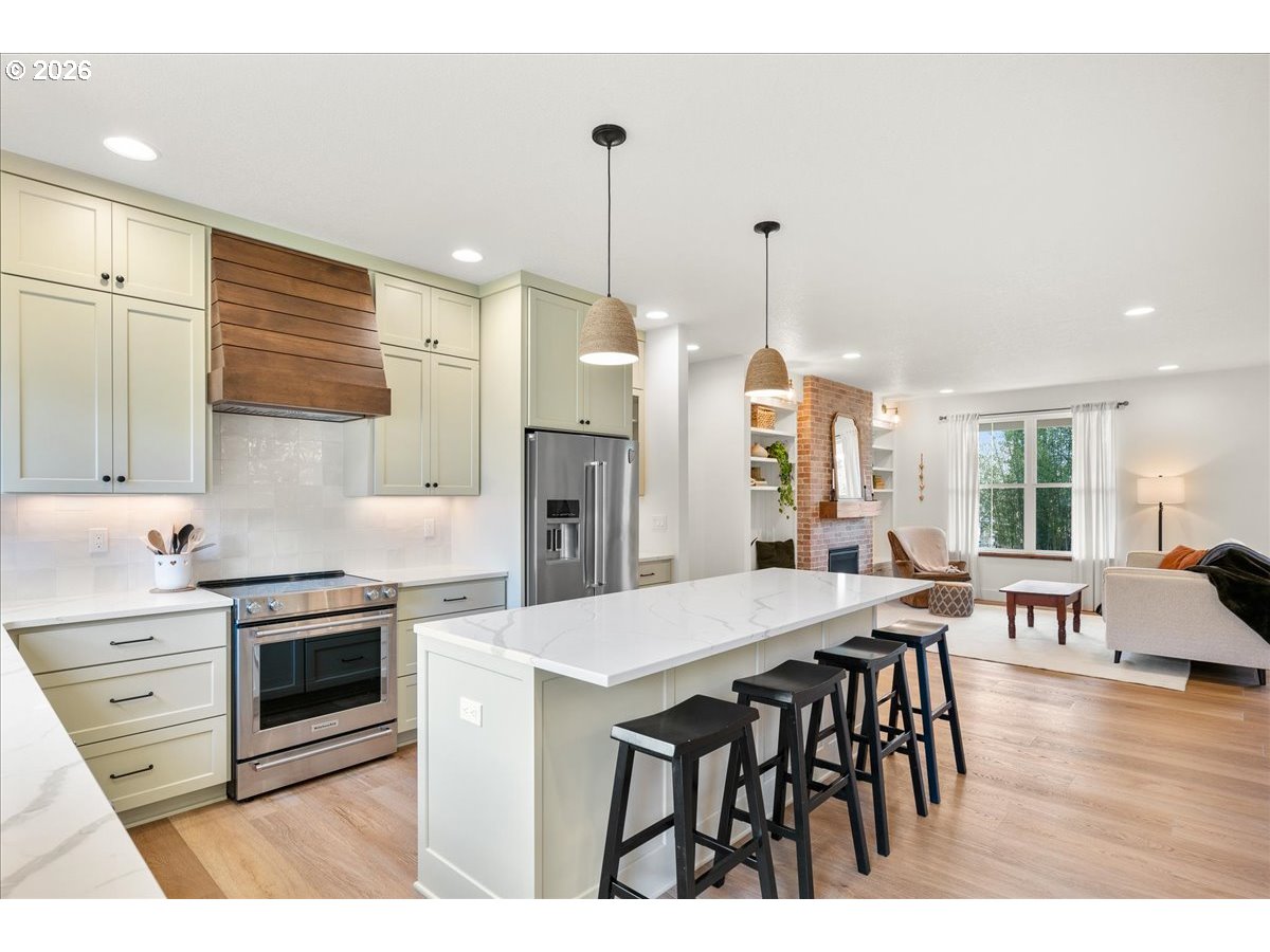 1305 Uff Da Street Silverton, OR 97381 - Photo 18 of 46 a kitchen with stainless steel appliances kitchen island granite countertop a table chairs and a refrigerator