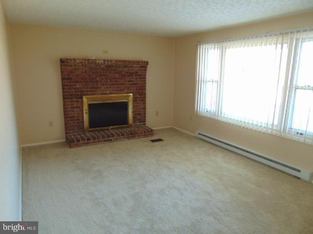 3623 Carrollton Road Upperco, MD 21155 - Photo 7 of 20 a view of an empty room with a fireplace and a window