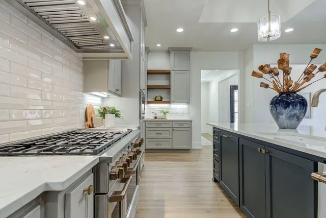 a kitchen with stainless steel appliances granite countertop a stove a sink dishwasher and a refrigerator