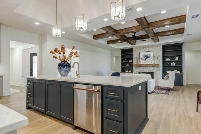 a kitchen with a sink a counter space appliances and cabinets