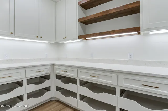 a view of white cabinets and a wooden floor