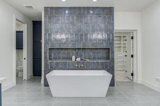 a bathroom with a tub sink and mirror