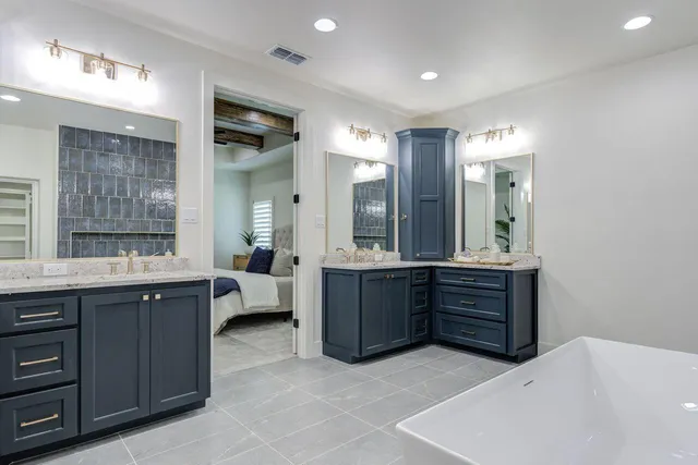 a bathroom with a vanity a sink a large mirror and a shower