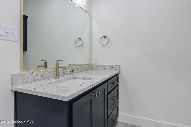 a bathroom with a granite countertop sink toilet and a mirror