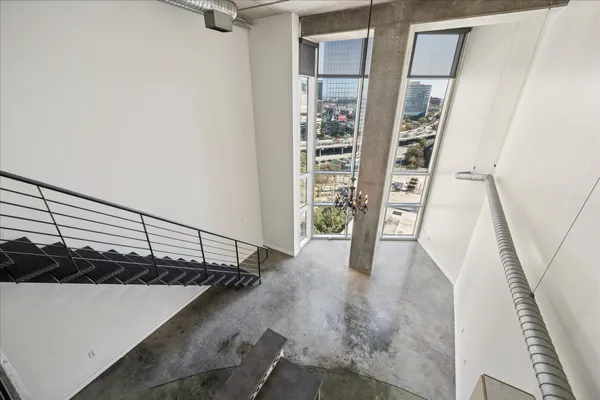 a view of staircase with railing and white walls