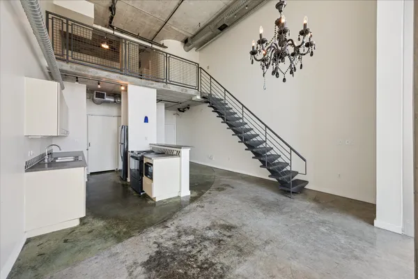 a view of a hallway with stairs and a chandelier