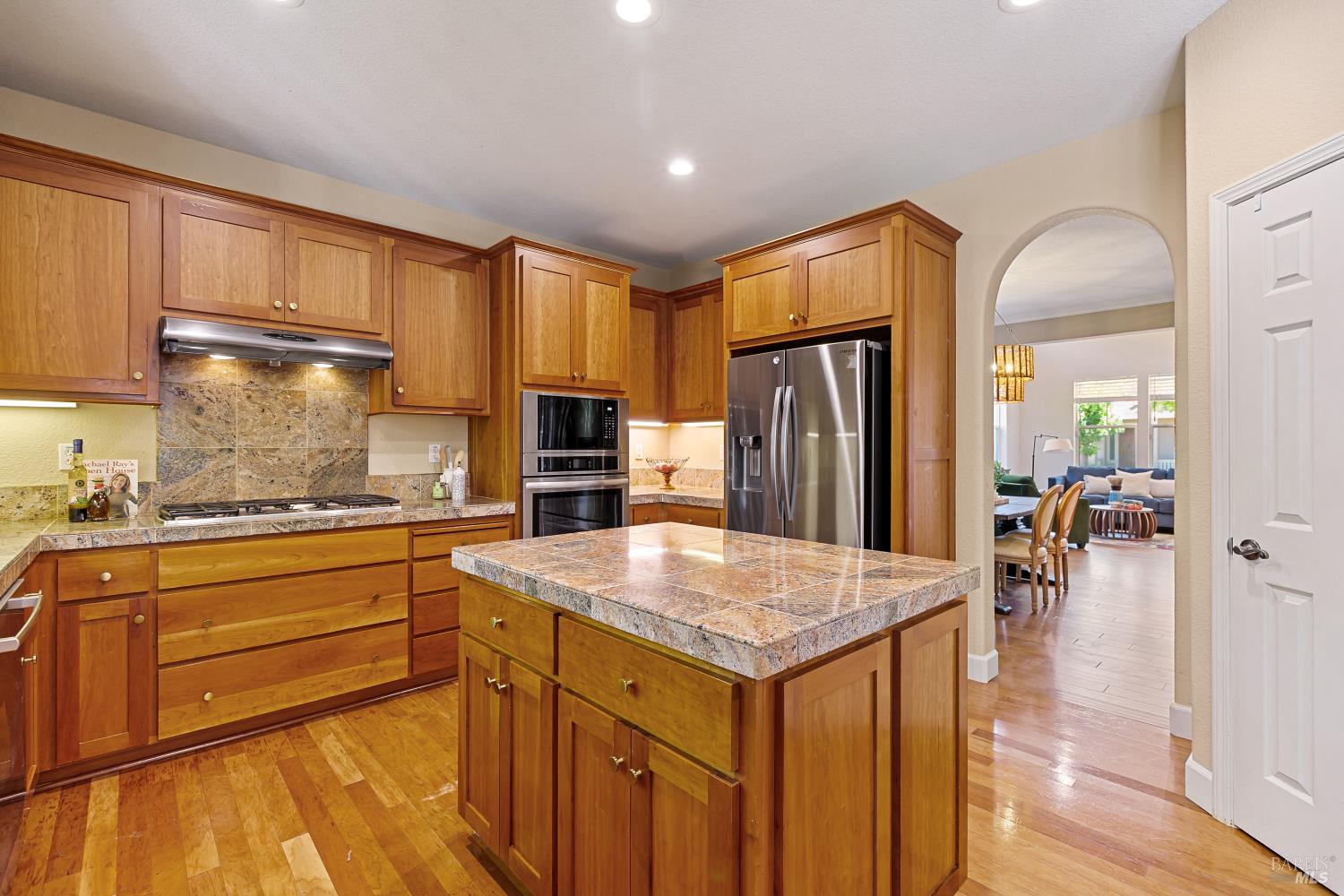 68 Pinheiro Circle Novato, CA 94945 - Photo 15 of 82 The generous center island anchors this beautifully designed kitchen, offering abundant prep space and storage. Warm cherry cabinetry, granite countertops, and an open flow into the dining area make hosting effortless.