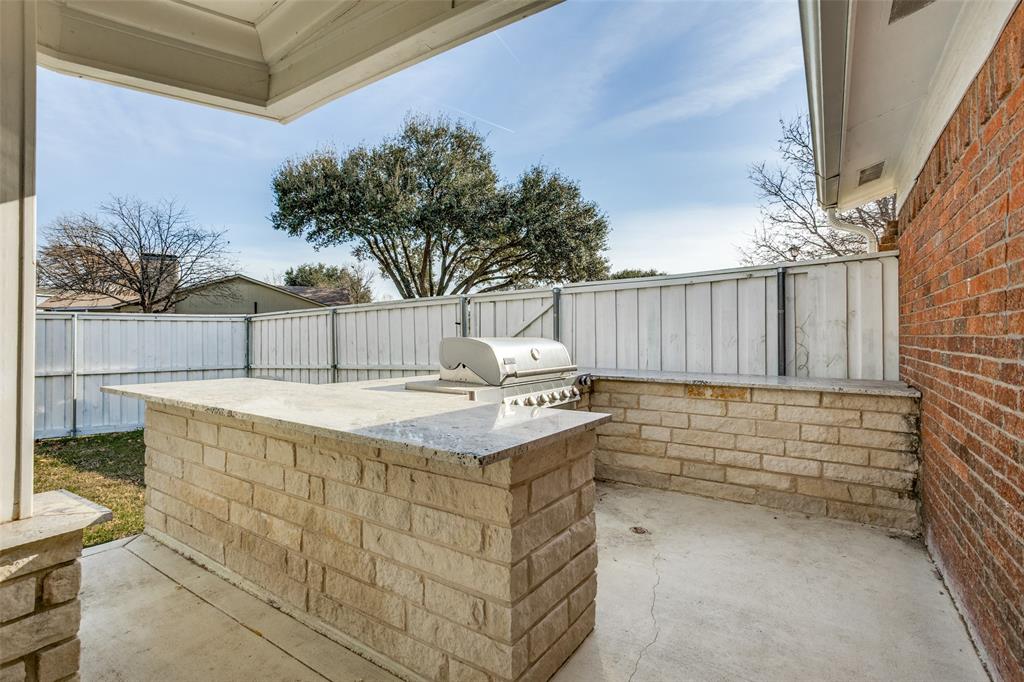 5702 Galaxie Road Garland, TX 75044 - Photo 18 of 21 Outdoor kitchen featuring a built-in grill and generous prep space — ideal for al fresco dining and seamless indoor-outdoor living.