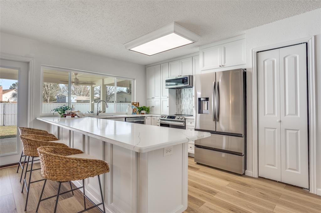 5702 Galaxie Road Garland, TX 75044 - Photo 5 of 21 Beautifully updated kitchen features a large peninsula, quartz countertops and stainless steel appliances