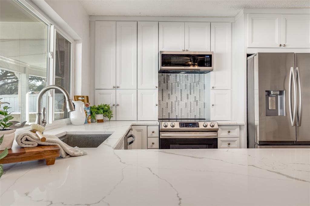 5702 Galaxie Road Garland, TX 75044 - Photo 6 of 21 Beautifully updated kitchen features a large peninsula, quartz countertops and stainless steel appliances