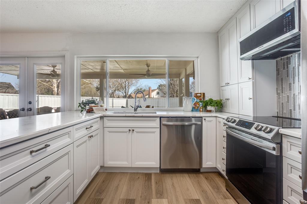 5702 Galaxie Road Garland, TX 75044 - Photo 7 of 21 Beautifully updated kitchen features a large peninsula, quartz countertops and stainless steel appliances