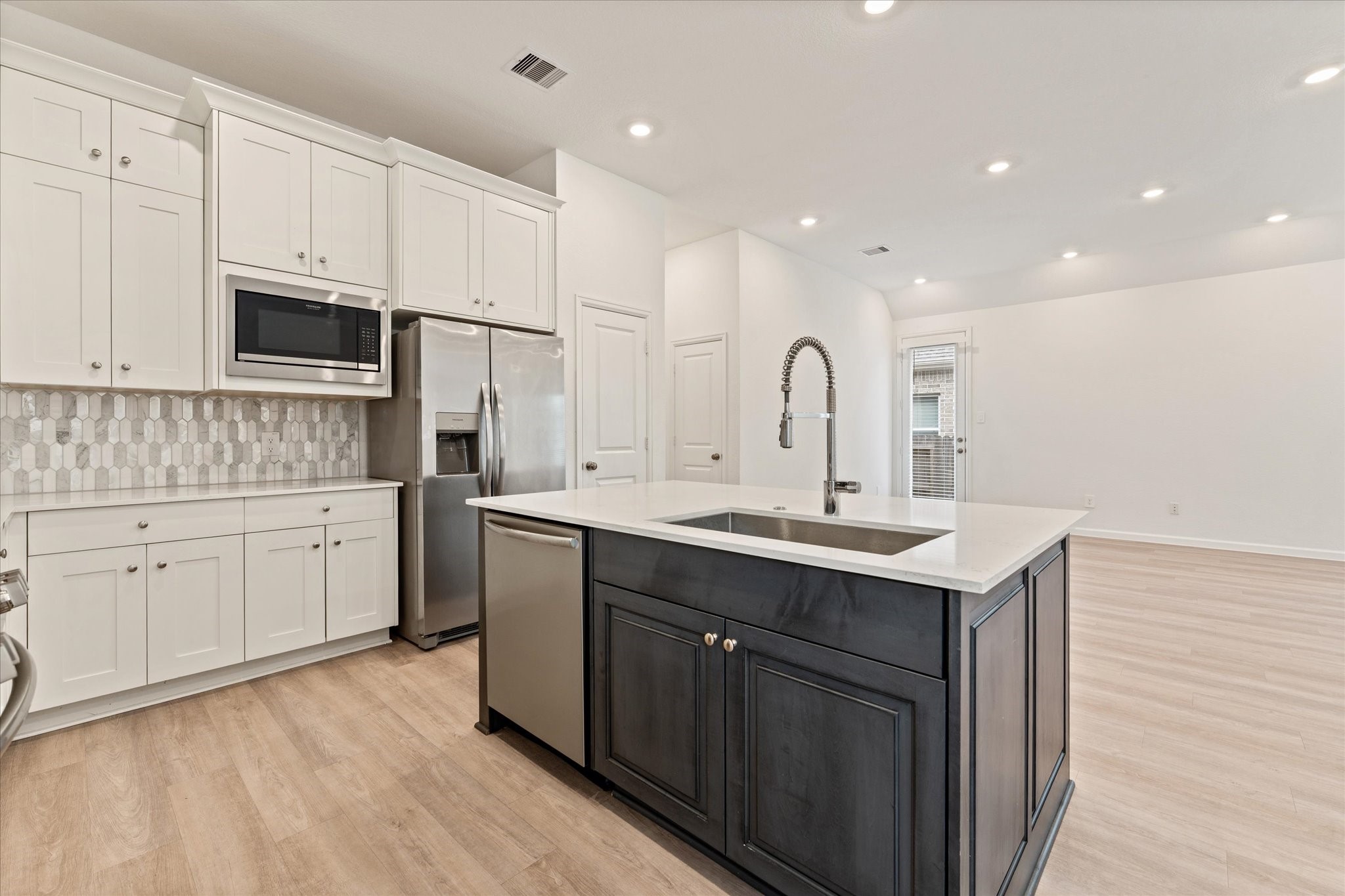 15520 Sunset Maple Court Conroe, TX 77302 - Photo 12 of 47 a kitchen with white cabinets sink and stainless steel appliances