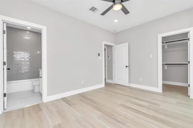 wooden floor in an empty room with a bathroom
