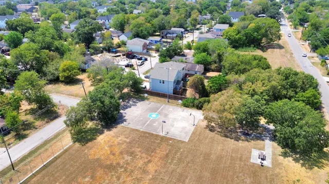 an aerial view of a house with a yard and greenery