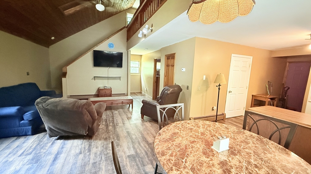 1755 Maple Street Dighton, MA 02764 - Photo 11 of 23 a bedroom with a bed a table and chair with wooden floor