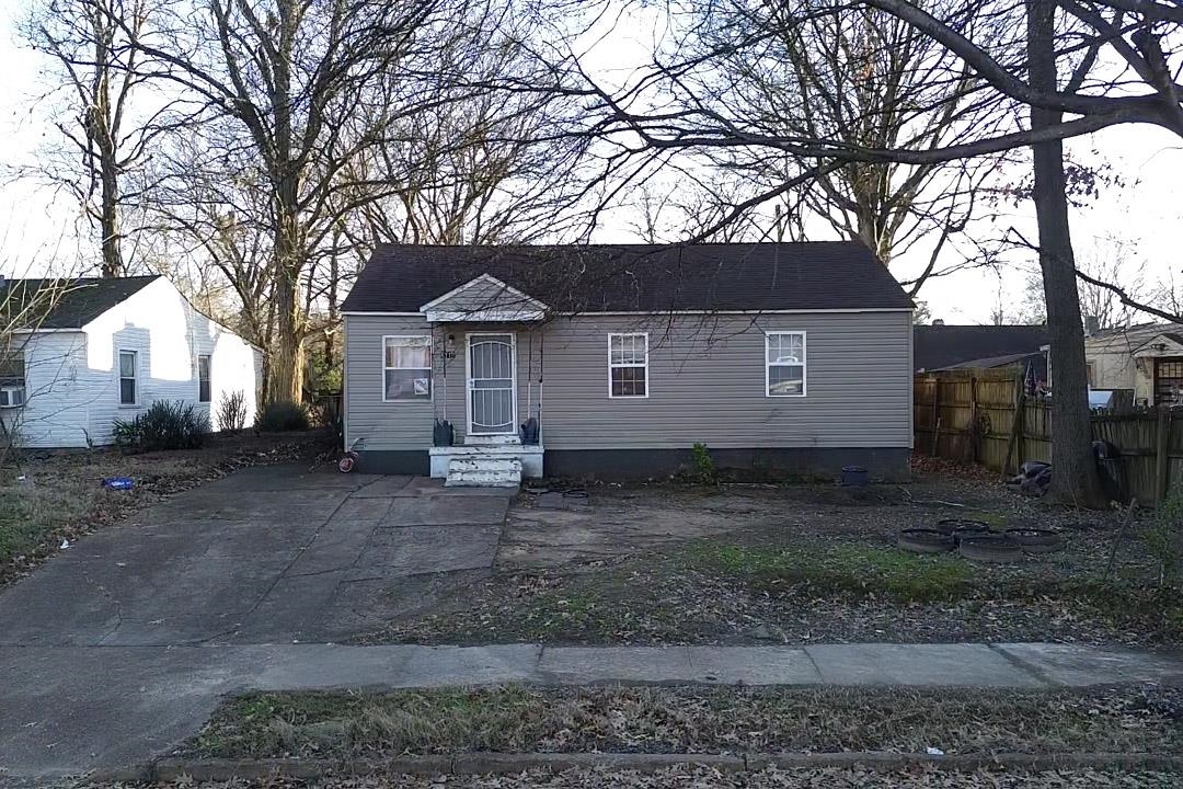 a view of a house with a yard and large tree