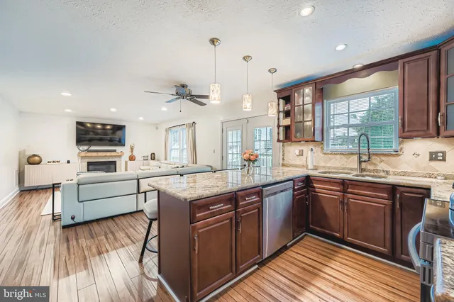 a large kitchen with stainless steel appliances granite countertop a lot of counter space and wooden floors