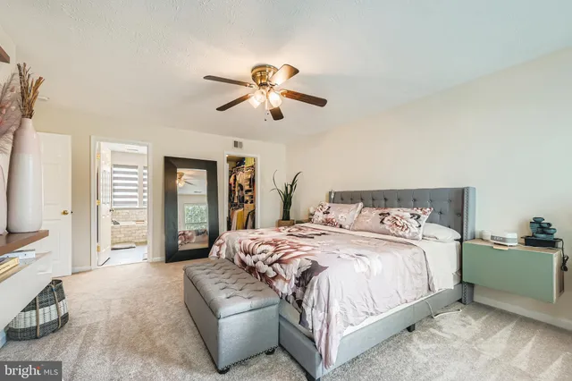 a bedroom with a large bed and a chandelier
