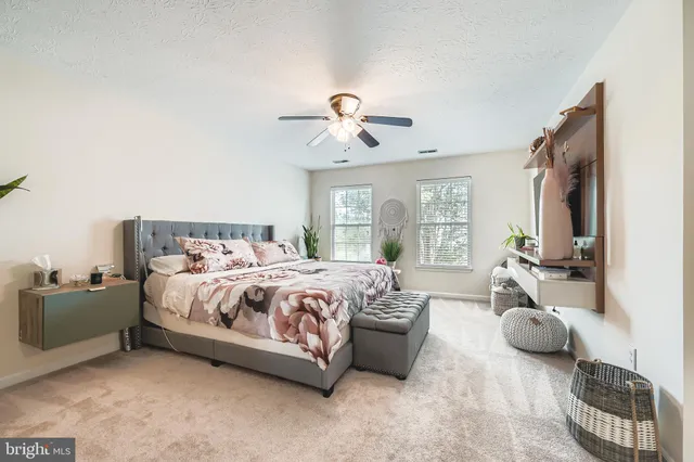 a spacious bedroom with a bed and ceiling fan