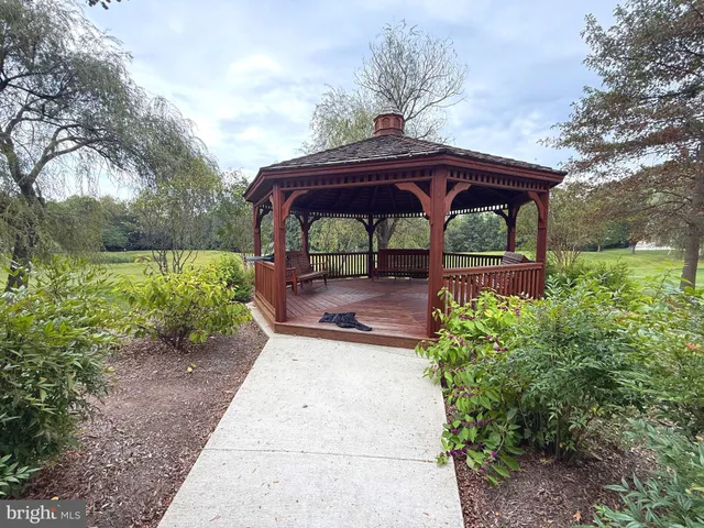 a view of backyard with a table and chairs under an umbrella