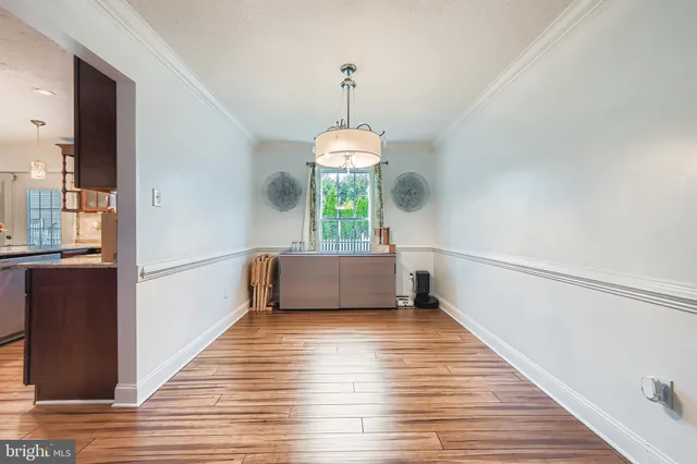 a view of a hallway with wooden floor and a chandelier