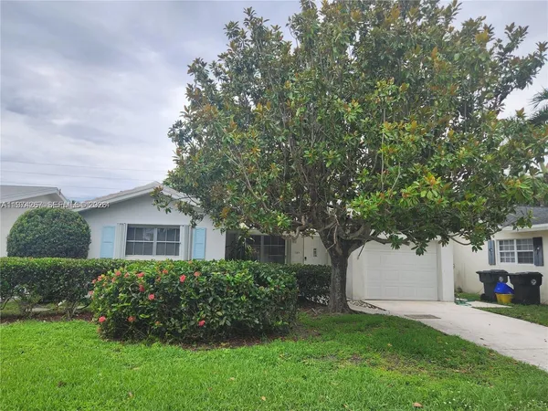 a front view of a house with a yard and trees