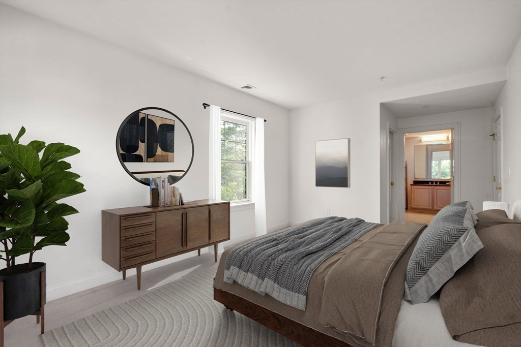 121 Centre Street, Unit PH3 Brookline, MA 02446 - Photo 14 of 32 a bedroom with a bed a mirror and a potted plant