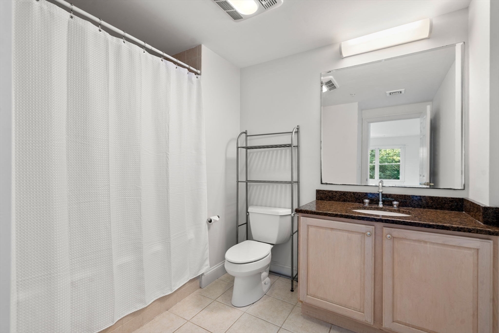 121 Centre Street, Unit PH3 Brookline, MA 02446 - Photo 19 of 32 a bathroom with a granite countertop sink a toilet and a mirror