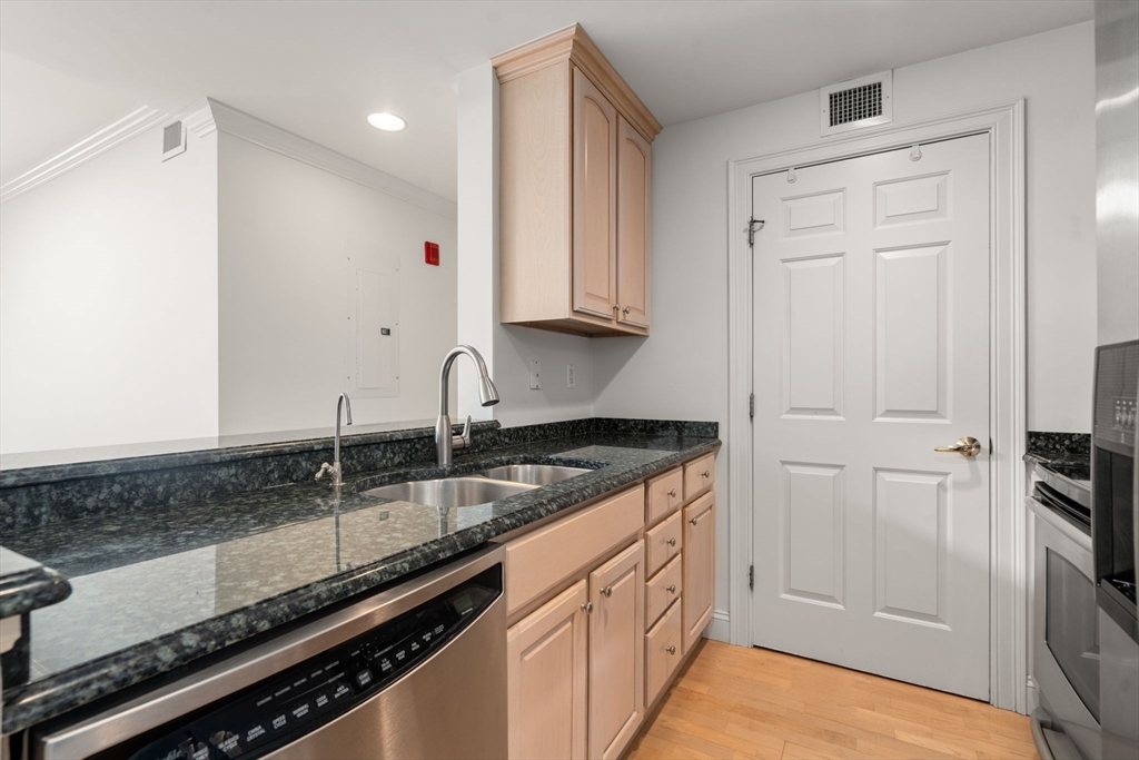 121 Centre Street, Unit PH3 Brookline, MA 02446 - Photo 3 of 32 a kitchen with granite countertop a sink and cabinets