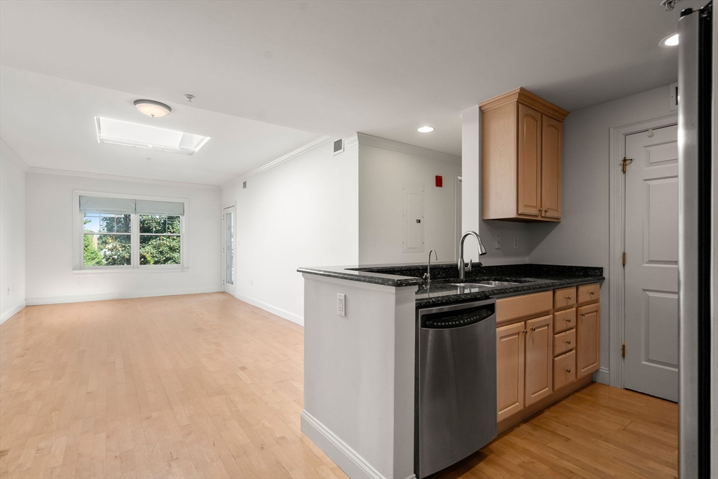 121 Centre Street, Unit PH3 Brookline, MA 02446 - Photo 4 of 32 a kitchen with stainless steel appliances granite countertop a stove and a refrigerator