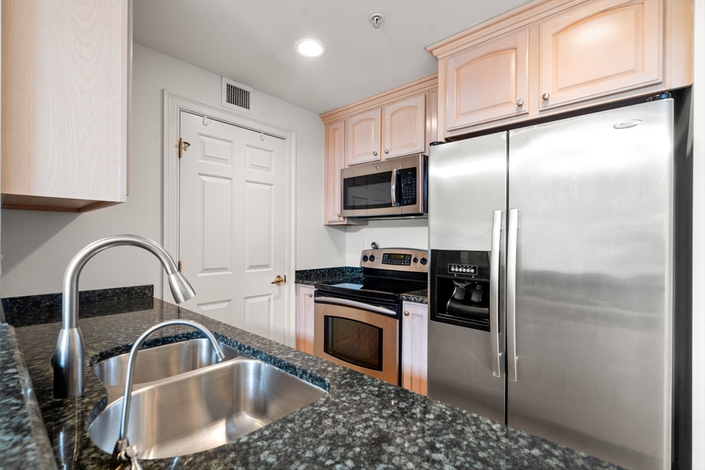 121 Centre Street, Unit PH3 Brookline, MA 02446 - Photo 6 of 32 a kitchen with stainless steel appliances granite countertop a refrigerator a sink a stove a microwave and cabinets