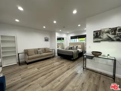 a living room with furniture and a wooden floor