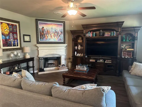 a living room with furniture a flat screen tv and a fireplace