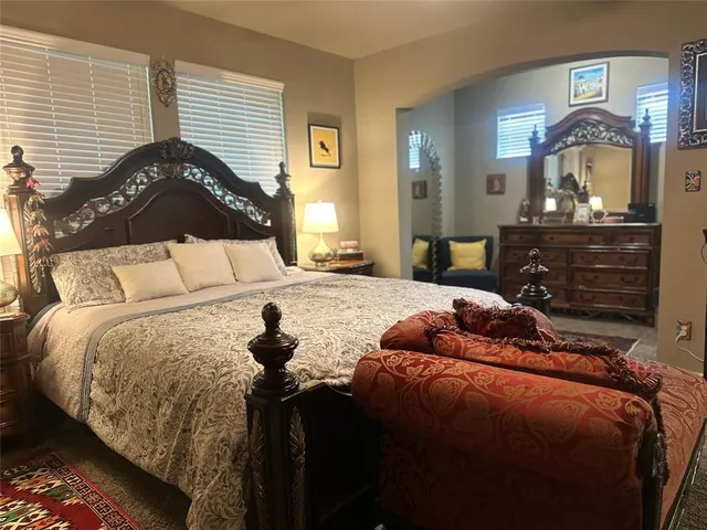 a bedroom with a bed and a mirror on the dresser