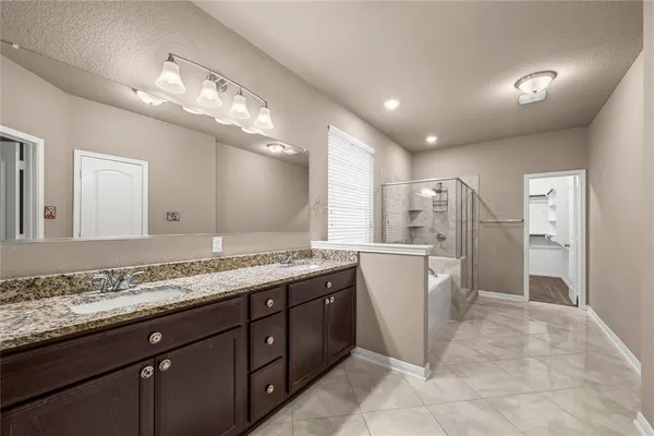 a bathroom with a granite countertop sink a large mirror and a shower